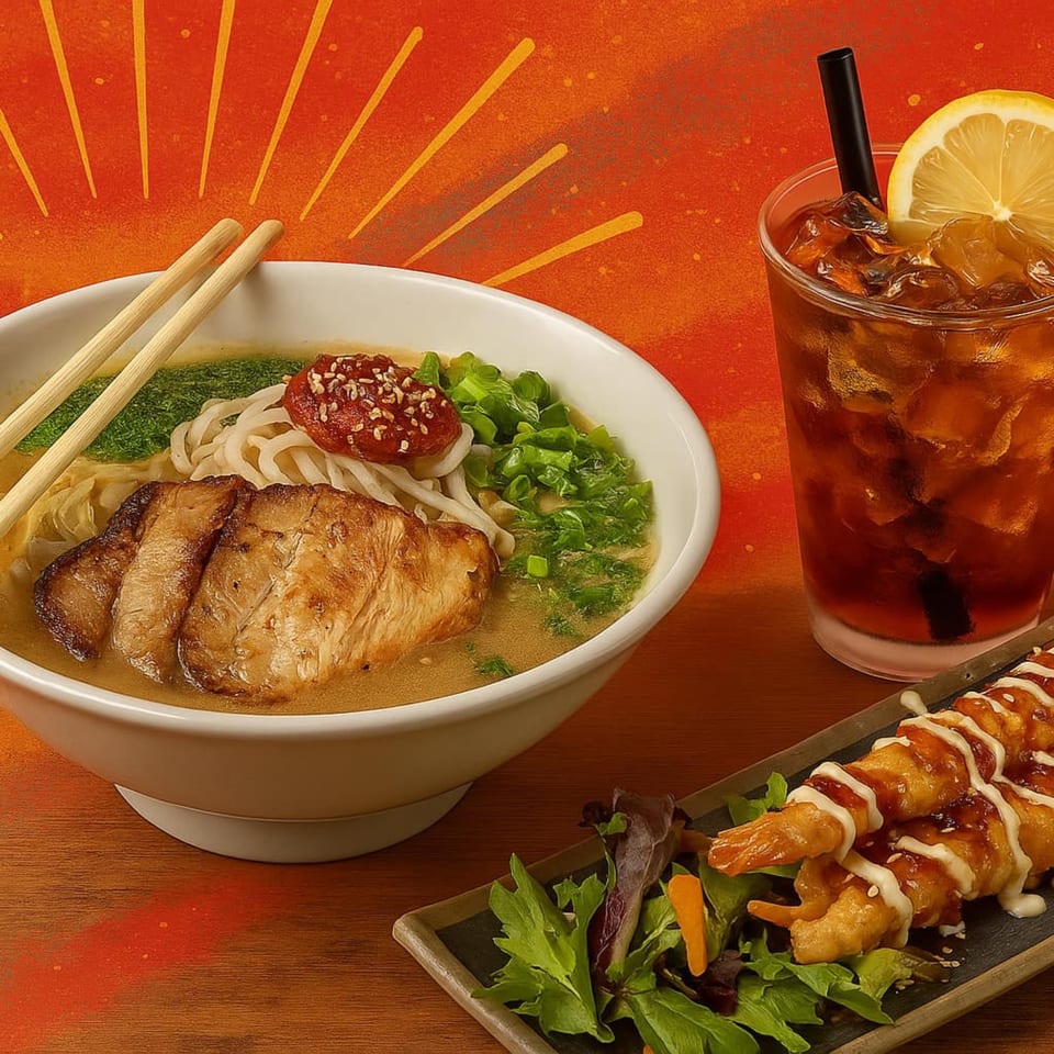 Ramen bowl with pork, iced tea with lemon, and shrimp tempura with salad on a wooden table.